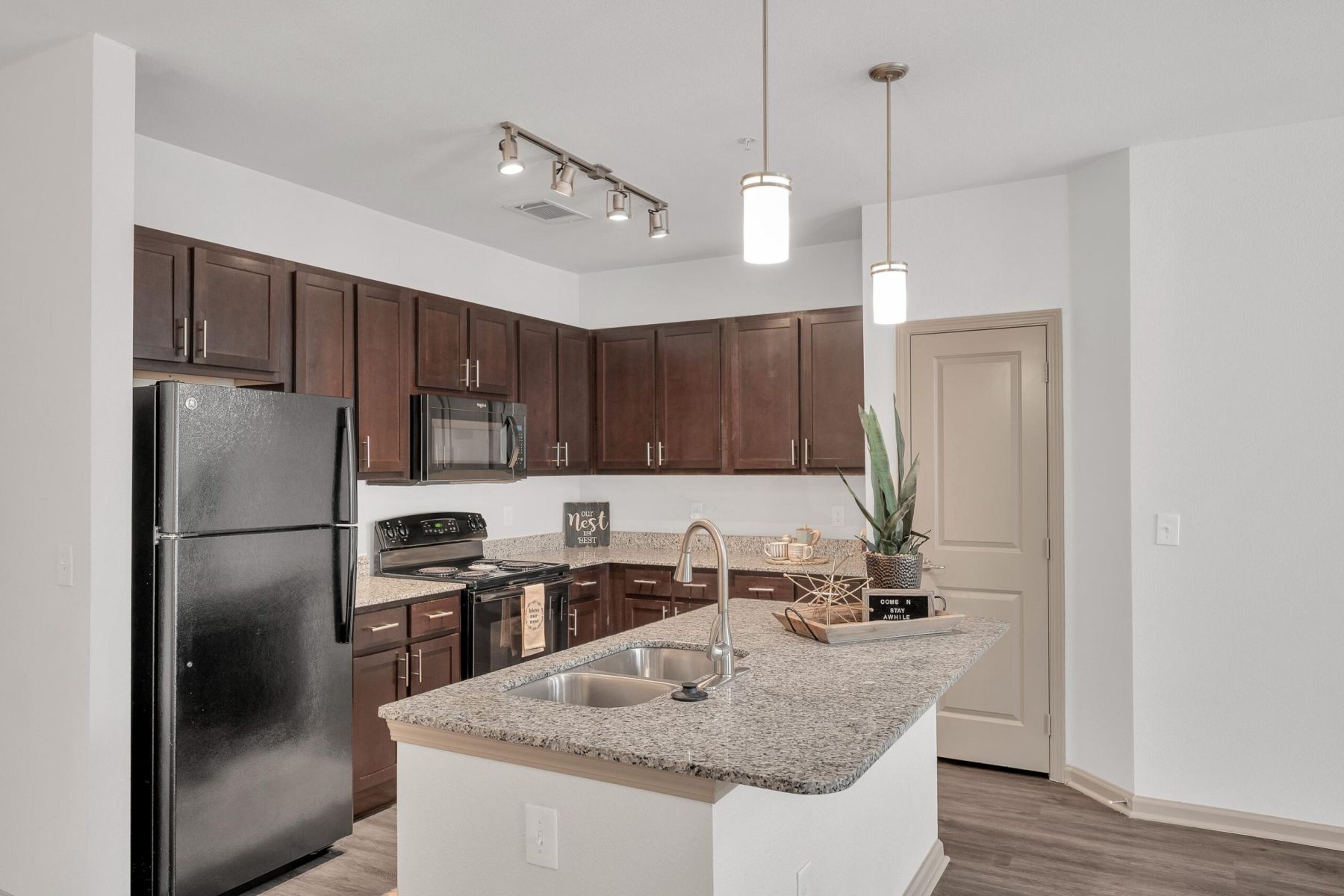 Luxury apartment kitchen with stainless steel appliances, granite countertops, and lots of storage space